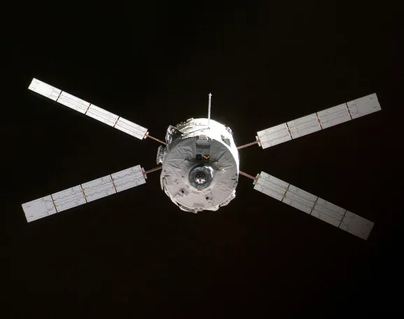 Photo du vaisseau cargo de ravitaillement Jules Verne ATV. Le véhicule automatique de transfert qui abrite les marchandises est de forme cylindrique et entouré de quatre pales sur chacune desquelles sont fixés quatre panneaux solaires.