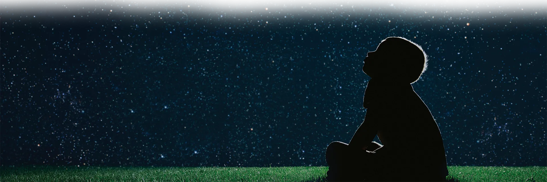 Illustration décorative d’un enfant assis par terre qui regarde le ciel étoilé.